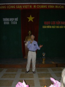 Morgan sings “The Mountains” at Teacher’s Day in Hue, with Ho Chi Minh presiding behind him.